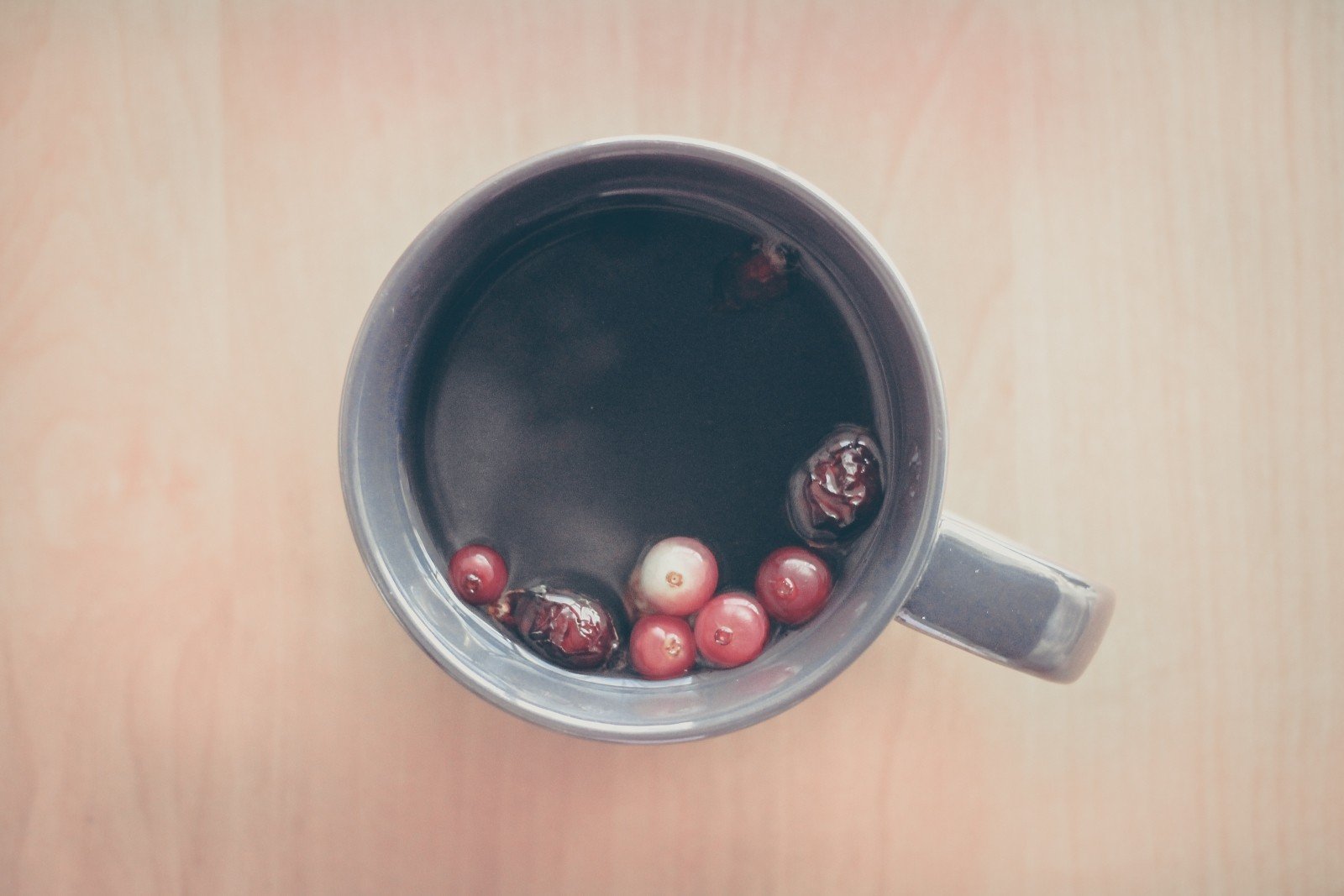 A cup of tea with berries viewed from above